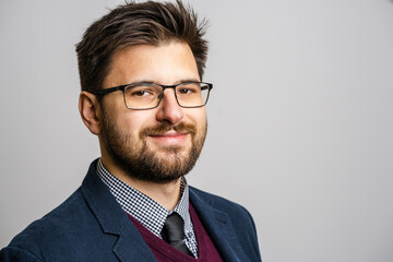 Portrait of one adult caucasian man 30 years old with beard and eyeglasses looking to the camera in...