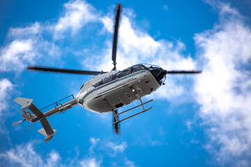 Helicopter close-up against the sky. Rescue helicopter flies in the sky with clouds.