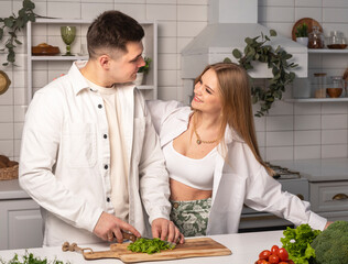 Love couple cooking meal, cutting vegetables for salad together at home kitchen. High quality photo