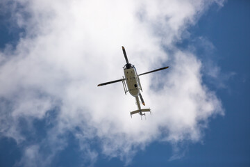 Helicopter close-up against the sky. Rescue helicopter flies in the sky with clouds.