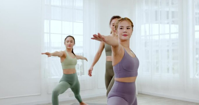 Group young Asian women practicing yoga in sport wear in clean gym. Daily exercise help your body burn fat and strong healthy muscles. Leisure Workout activities for young people health care concept