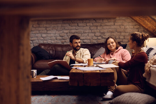 University friends talk while studying together at home.