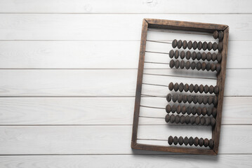 Old retro abacus on the white wooden flat lay table background with copy space.