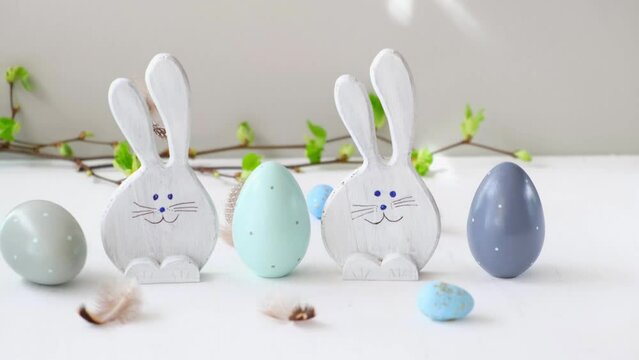 Easter eggs and funny bunnys on white table. Happy easter. Festive wooden decoration. Holiday concept, springtime. High quality 4k footage