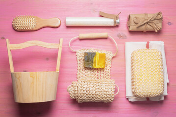 Bath or bath house background. Bathroom accessories on a pink wooden flat lay table.