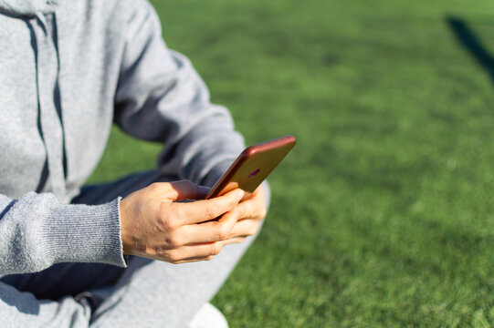 Woman With Phone On The Soccer Field.