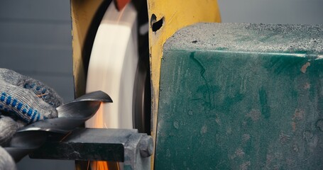 sharpen drill bits on a bench grinder, close up.
