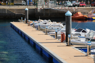 Floating dock with small boats in the harbor of Puerto de la Estaca on El Hierro. Boat trip in the...