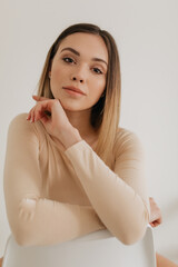 Adorable pretty woman with brown eyes, nude make up and light hair is posing at camera during photoshoot. Fashionable portrait of pretty woman