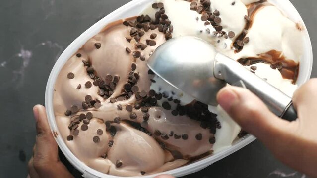 hand picking ice cream with a spoon from a bowl 