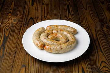 meat products on a white plate on a wooden table

