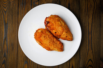 meat products on a white plate on a wooden table
