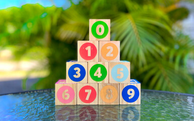 wooden numbers cubes for kids. cubes on the table and palm tree in the background