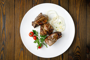 meat products on a white plate on a wooden table
