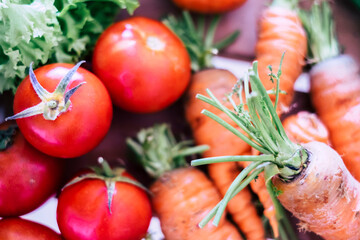 Close up of fresh biological vegetables like carrots and tomatoes on the table. Healthy food lifestyle with vitamin. Salads ingredients. Farm store zero kilometros concept business