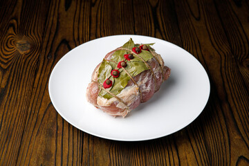 meat products on a white plate on a wooden table
