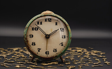 vintage table clock on ornamental keys background