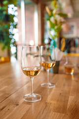 Two glass of white wine on a wooden table at cafe or restaurant. 