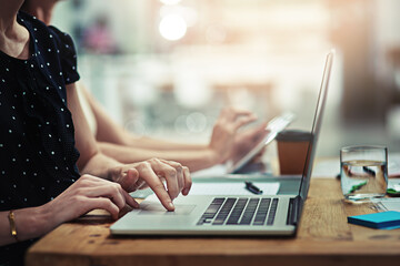 Get to work on your success story. Cropped shot of an unrecognisable businesswoman working on a laptop in an office.