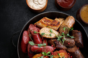 Grilled meat platter in a pan and sauces