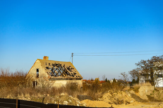 an old dilapidated abandoned house on vacant lot. Private house with a ruined roof
