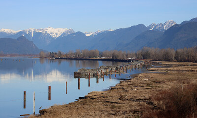 Peaceful river reflects snow-capped mountains