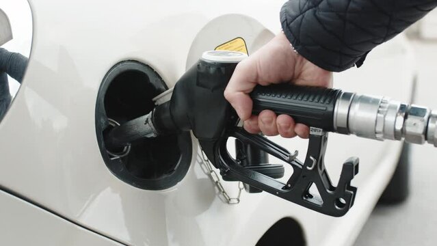 Hand puts diesel fuel pump into car