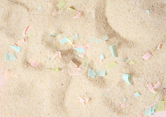 Conceptual composition of microplastics and coastal sand. The impact of microplastic on nature. The idea of micro plastic pollution. The concept of environmental damage. Close-up