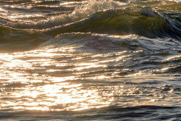 Sea waves at sunset. Sun glare in the waves.