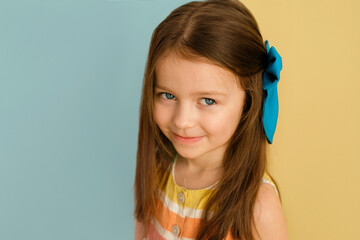 A beautiful cute blue-eyed girl with a big bow in her long hair. Fashion accessories and hair...