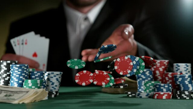 Poker player throwing poker chips on casino table in super slow motion, filmed on high speed cinema camera at 1000 fps. Gambling background.