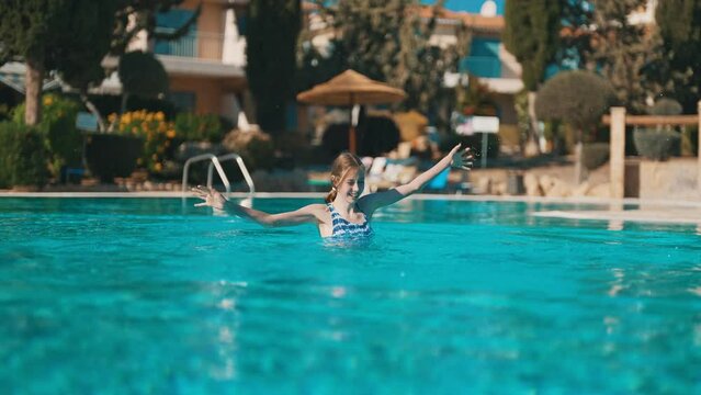Happy tween girl in swimming pool. Vacations concept.
