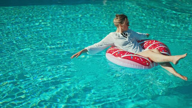 Woman relaxing in swimming pool at vacation.