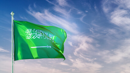 Saudi Arabia flag on flagpole against blue sky