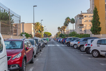 Street of a tourist town crowded with cars parked on the sides