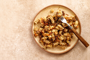 Spiral pasta with stew beef on plate and beige background. Pasta Russian Navy Style. Fusilli