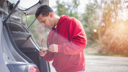 handsome young Hispanic crashed with his car using his cell phone. road safety concept