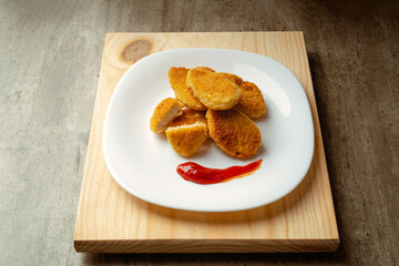 Chicken nuggets with crispy fried bread, wooden bottom. Tasty chicken nuggets.