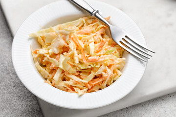 Coleslaw cabbage salad with cabbage, carrots, herbs and sesame seeds on a white plate. Healthy eating, vegan food