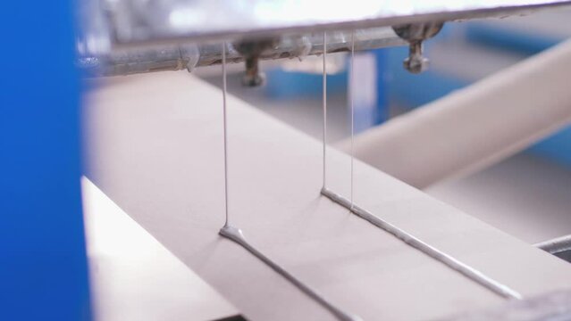 cardboard products. a cardboard factory produces paper corners. production. cardboard. paper. applying glue to cardboard. adhesive composition