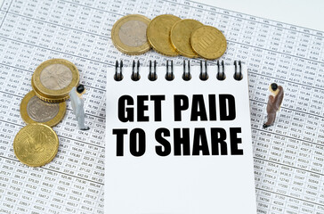 On financial reports there are figurines of people, coins and a notepad with the inscription - Get...