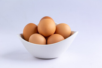 Upclose shot of Fresh eggs in a white bowl isolated on a white background.