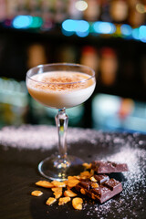 Cocktail garnished with dried chocolate on the bar counter. The concept of the correct preparation...