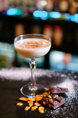 Cocktail garnished with dried chocolate on the bar counter. The concept of the correct preparation of drinks.