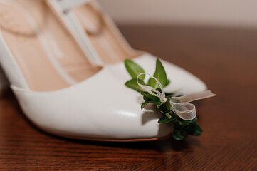 Obraz na płótnie Canvas White shoes, groom's boutonniere. Bride's morning, wedding accessories