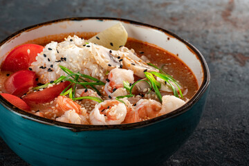 Spicy Tom yam soup based on coconut milk and shrimp. Spicy fish traditional soup from Asia in a blue bowl