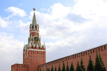 Fototapeta na wymiar Red square in Moscow with Kremlin tower, chimes and brick wall on cloudy sky background. Symbol of Russian authorities