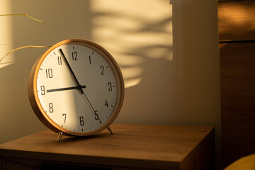 Sunshine on wooden clock in bedroom at morning 