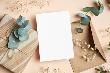 Greeting card mockup with gift box, envelope and natural eucalyptus twigs