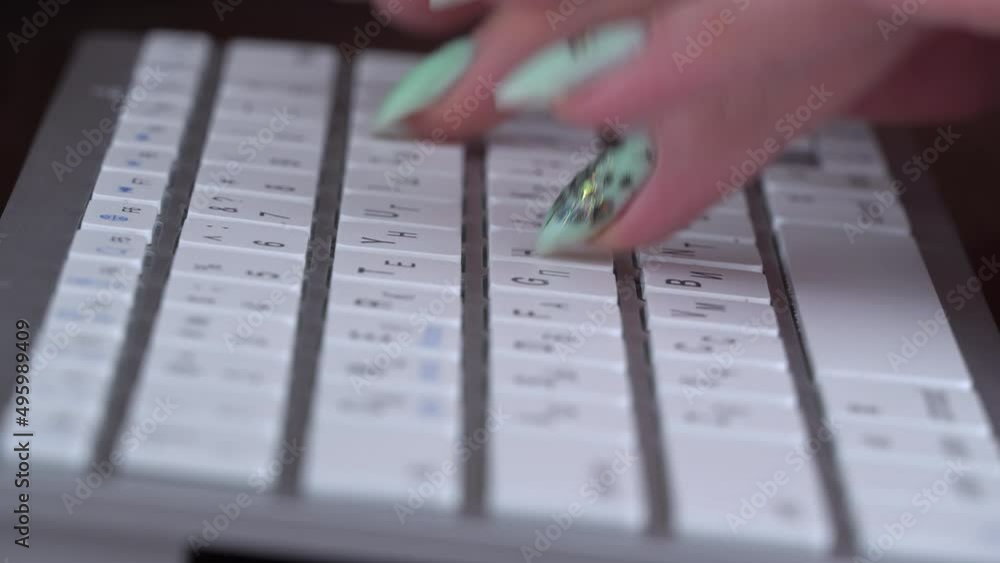 Poster business woman's fingers are typing on the keyboard of a white laptop. the hands of a young girl are
